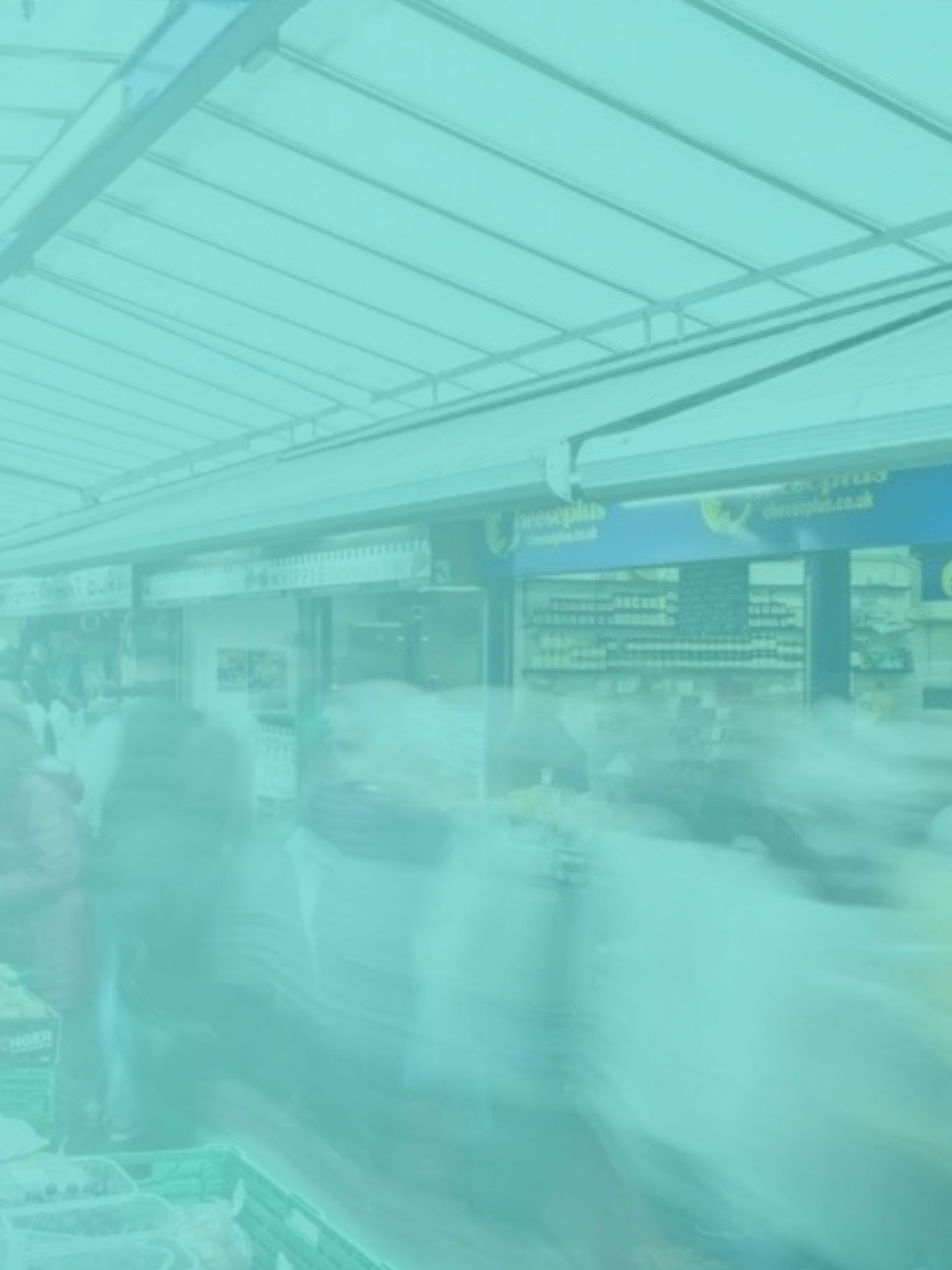 a bustling market with people walking around market stalls