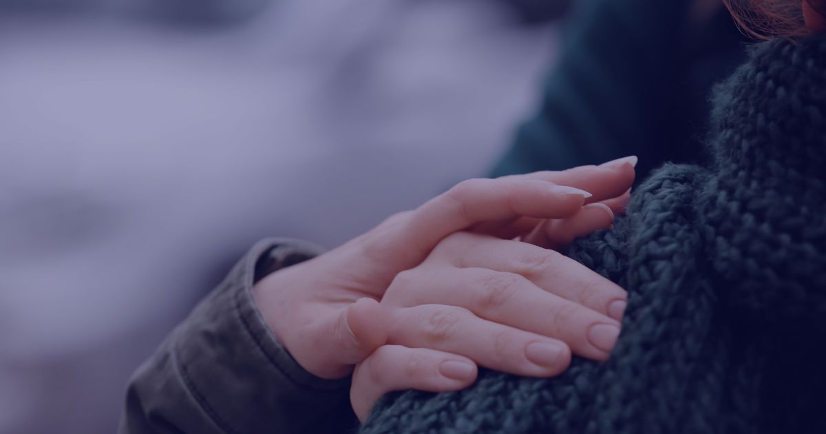 a close up of a hand holding a young persons hand in a comforting manner
