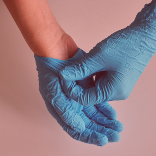 Two hands wearing blue latex gloves
