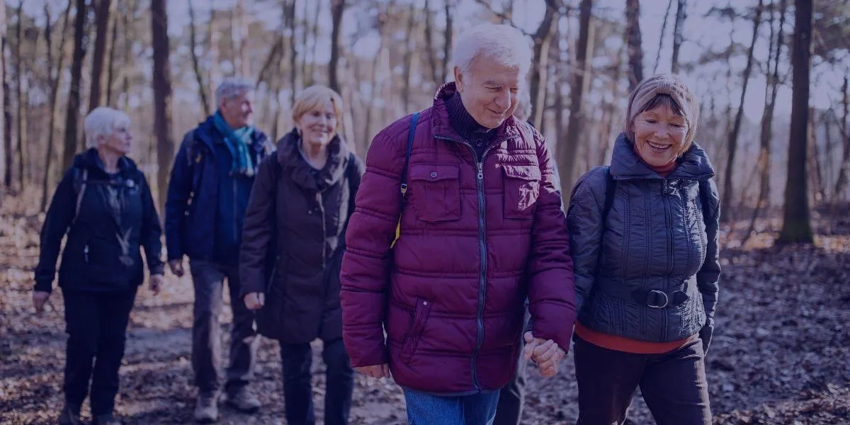 a group of 5 men and women walking together and smiling and laughing