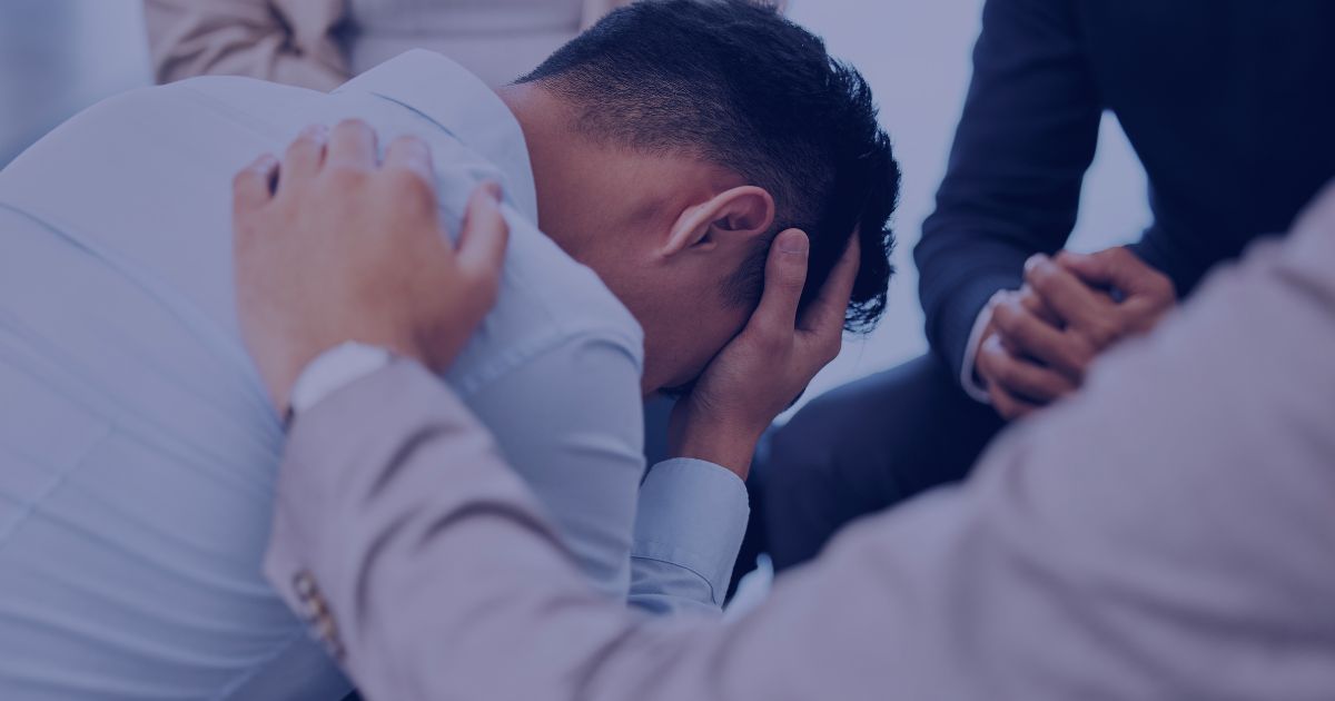 Person receiving support and comfort during a difficult moment in a group setting