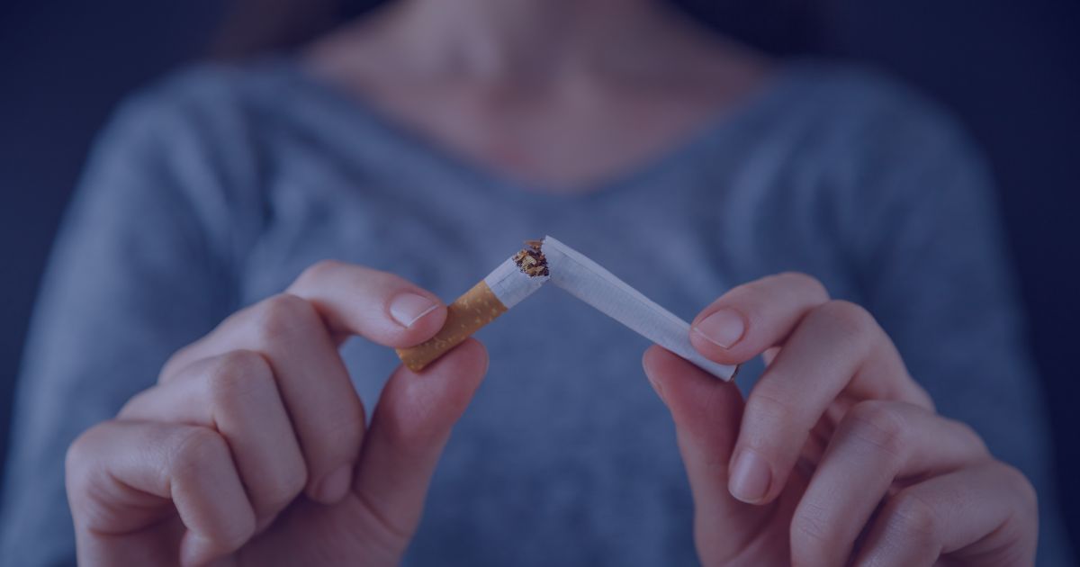 Hands breaking a cigarette in half.
