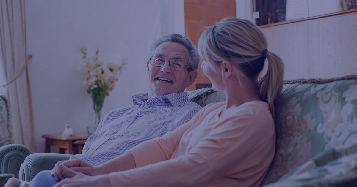 a man and a woman sat down, laughing together in homely surroundings