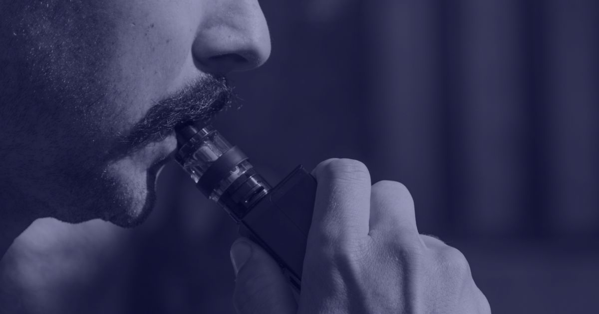 a man hold a vaping devices in his mouth