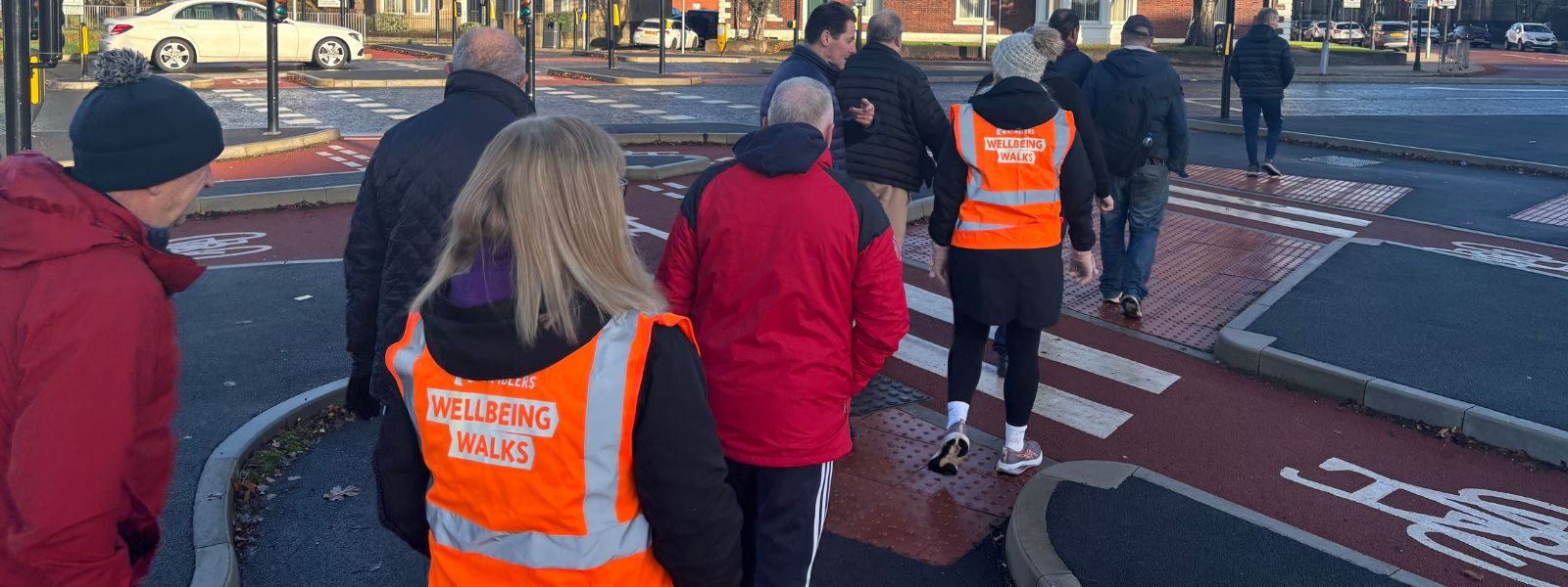 A group of people walking in Bury town centre on one of the local wellbeing walks.