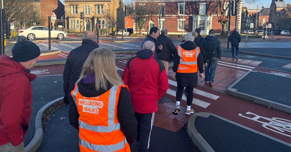 A group of people walking in Bury town centre on one of the local wellbeing walks.