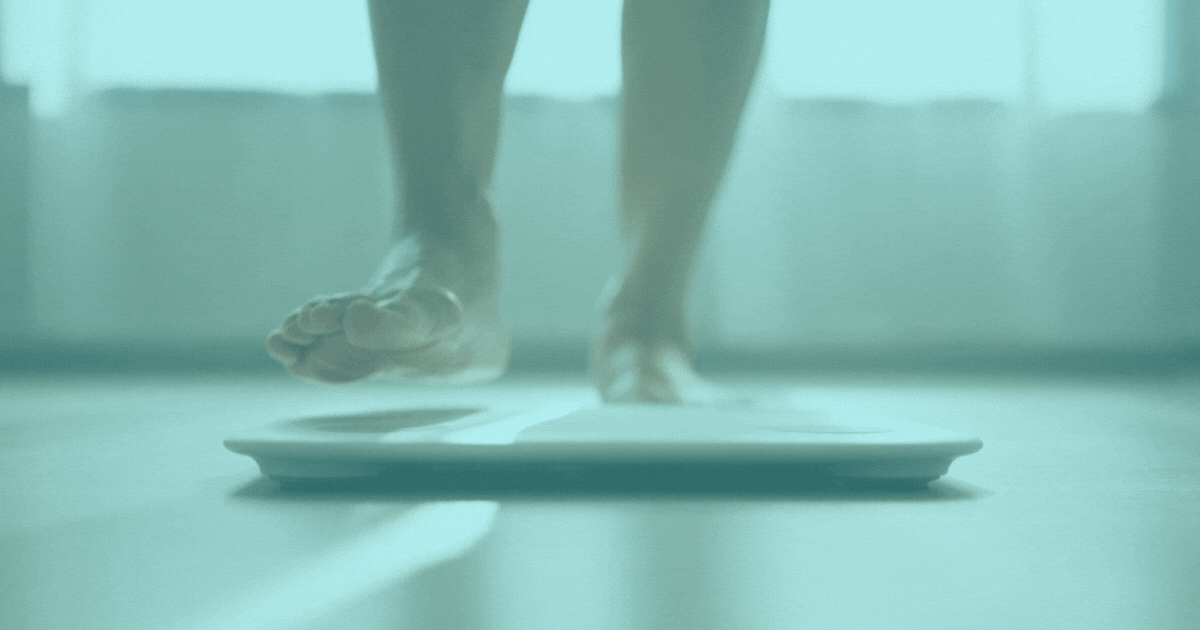 a man steps on to scales to weigh himself